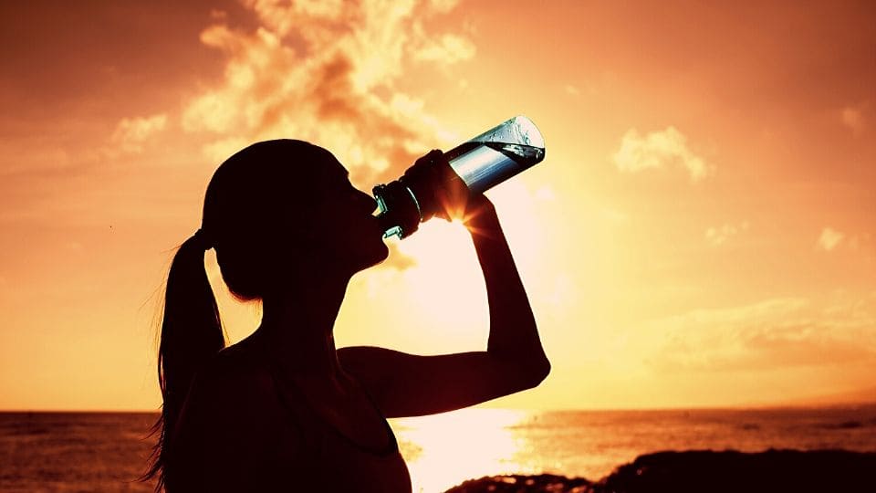 Ragazza beve acqua da una bottiglia