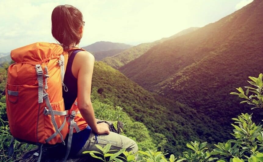 Ragazza zaino in spalla osserva il panorama
