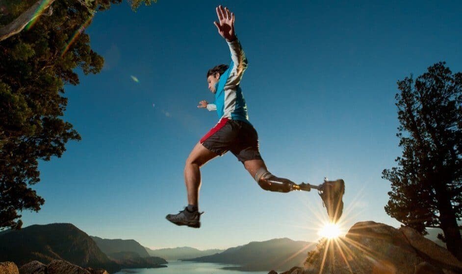 Ragazzo con protesi alla gamba salta al tramonto