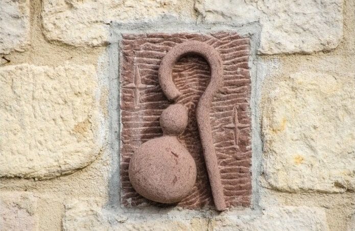 Scultura su parete con bastone e calabaza