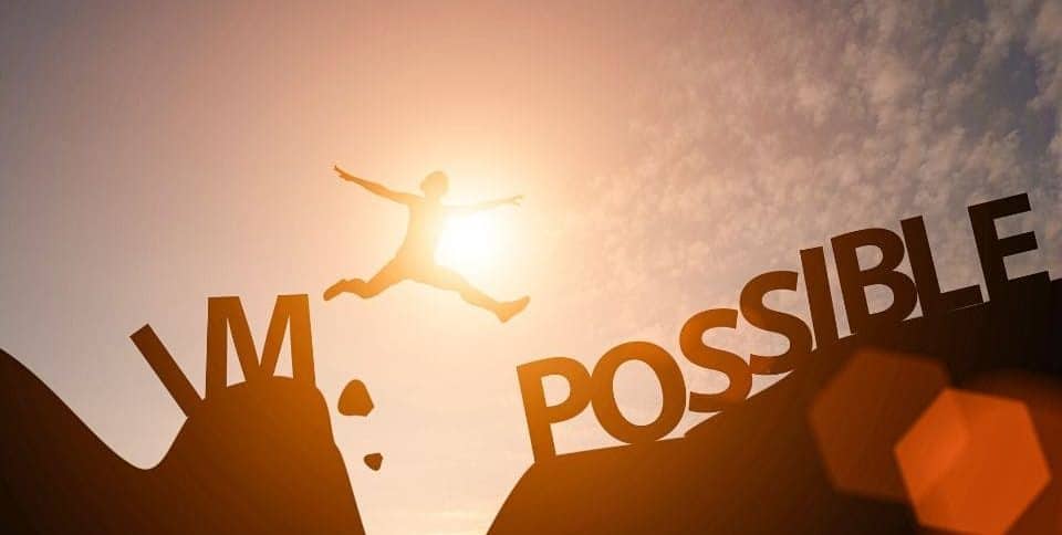 Un uomo salta e supera una grande scritta impossibile