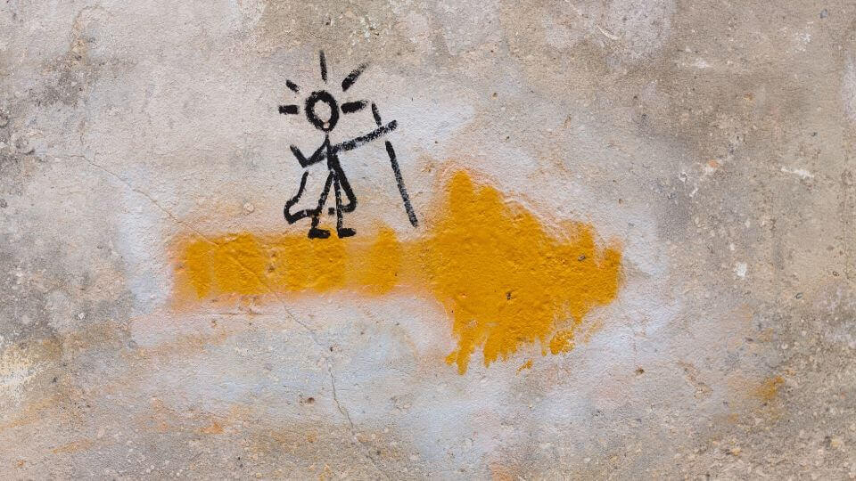 Una freccia gialla con pellegrino disegnato sopra