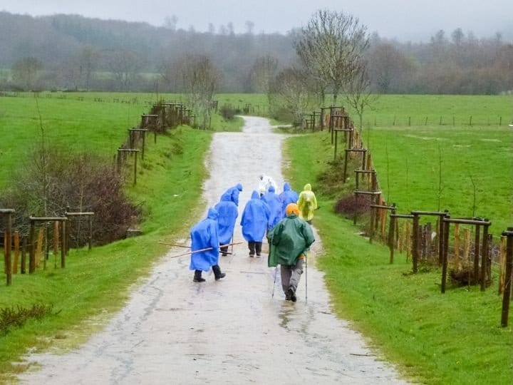 Pellegrini camminano sotto la pioggia
