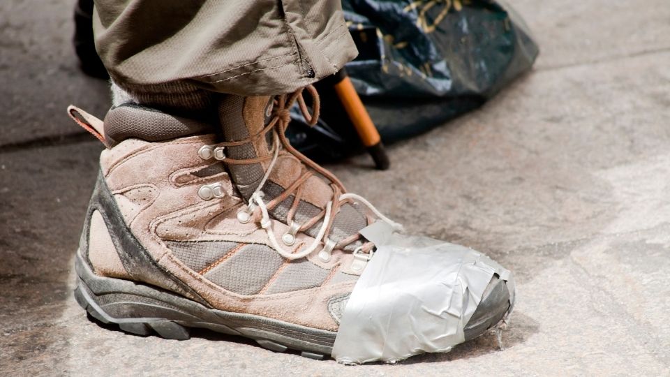 una scarpa da trekking riparata con il nastro